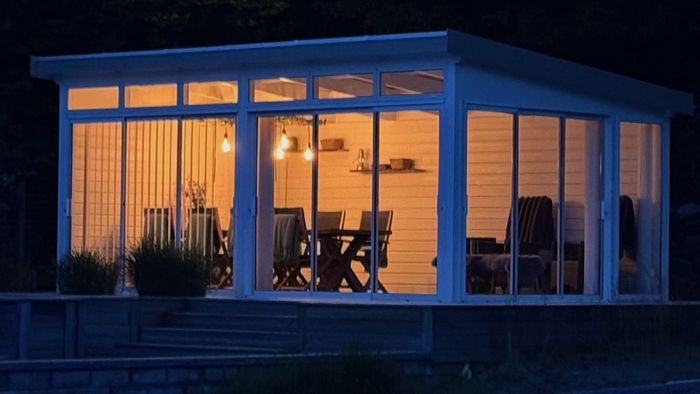 My cabin at night, with warm light spilling through its large windows